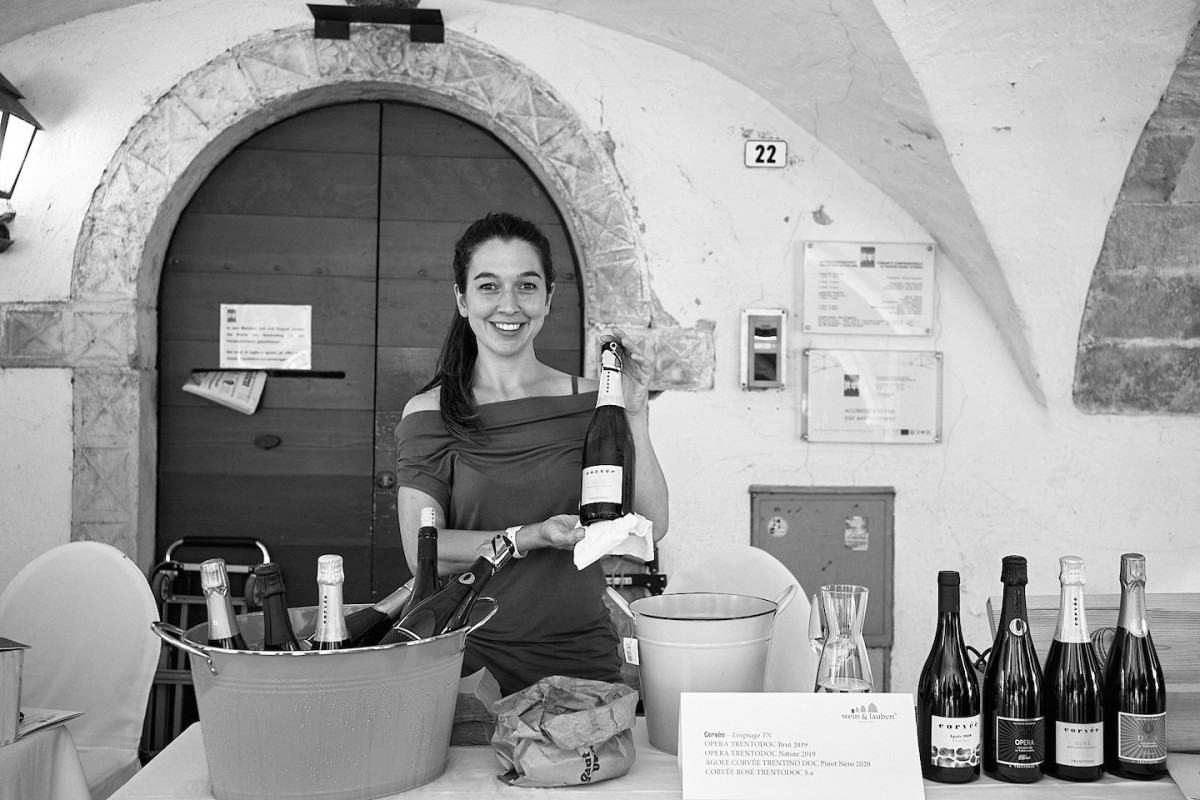 Eine Vertreterin von Corvée hält eine Flasche in die Kamera und präsentiert sie.