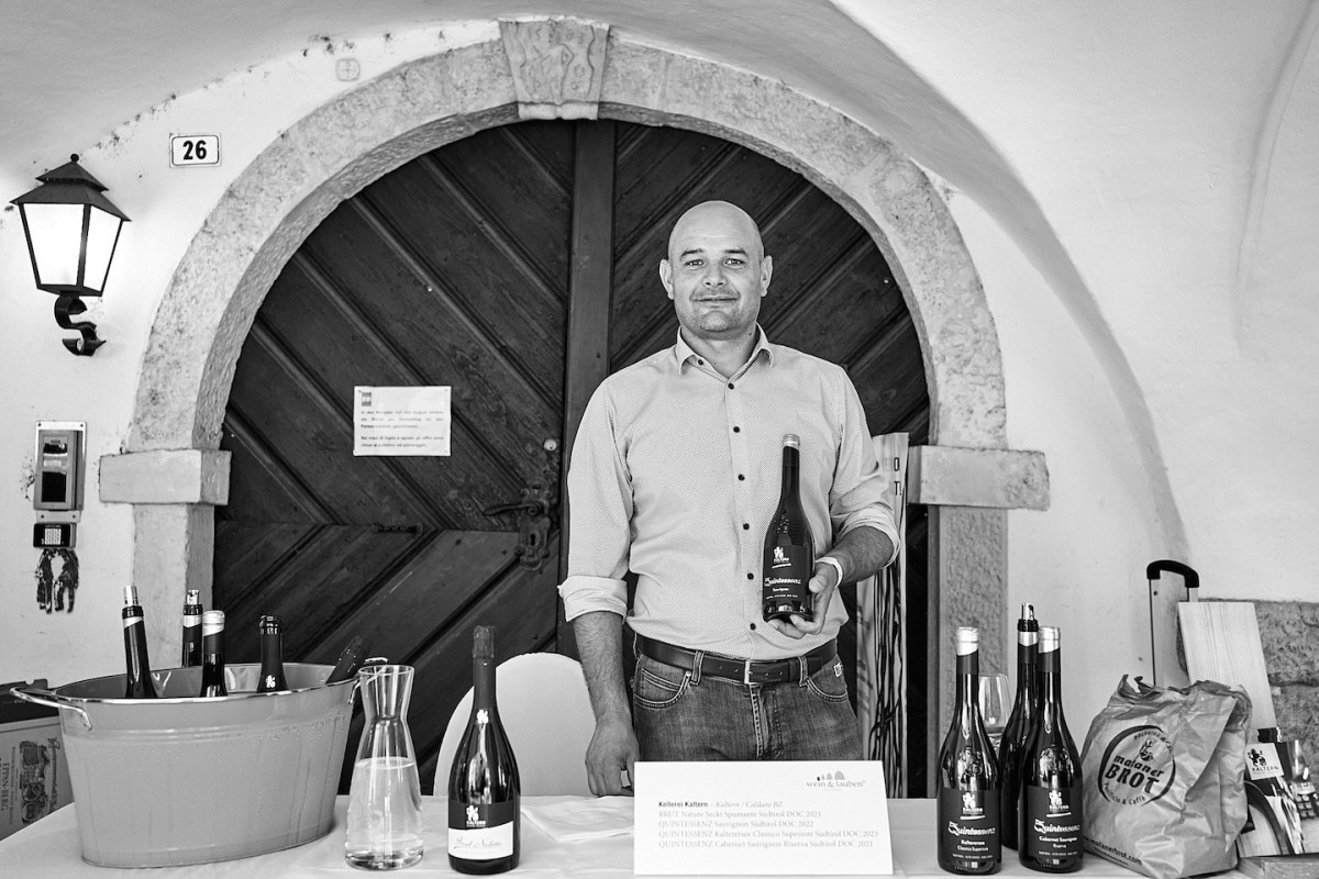 Ein Vertreter von Kellerei Kaltern steht hinter einem Tisch und präsentiert Weine.