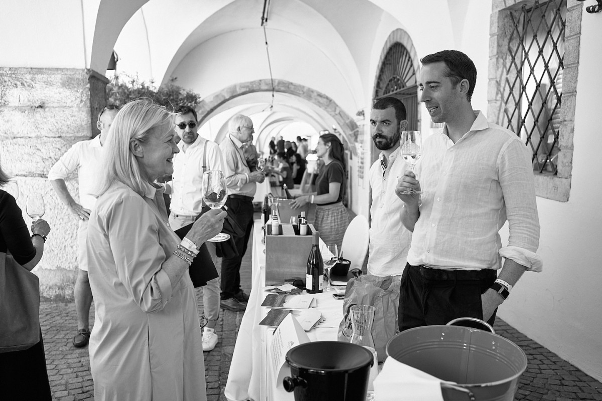 Ein Aussteller steht hinter einem Tisch und präsentiert Weine.